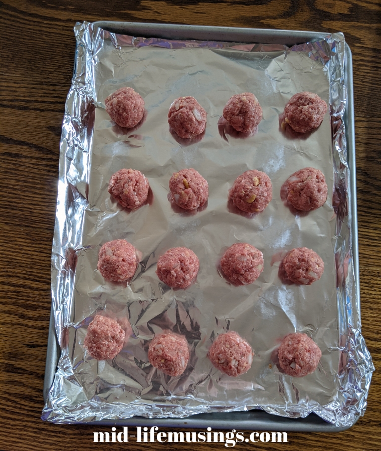 BBQ Meatballs on a foil-lined cookie sheet ready to be frozen for 1-2 hours.